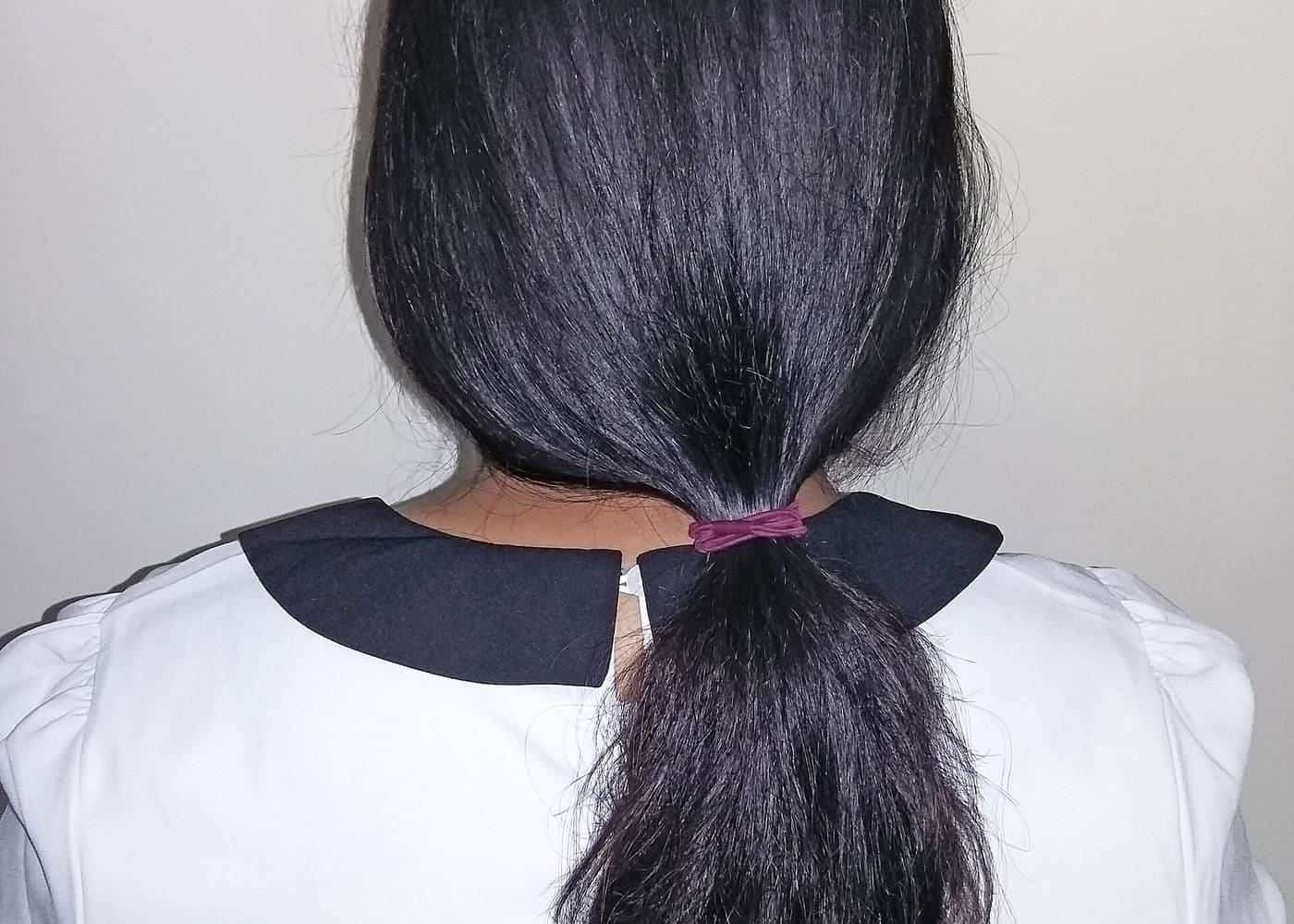 A low ponytail of long black hair seen from behind