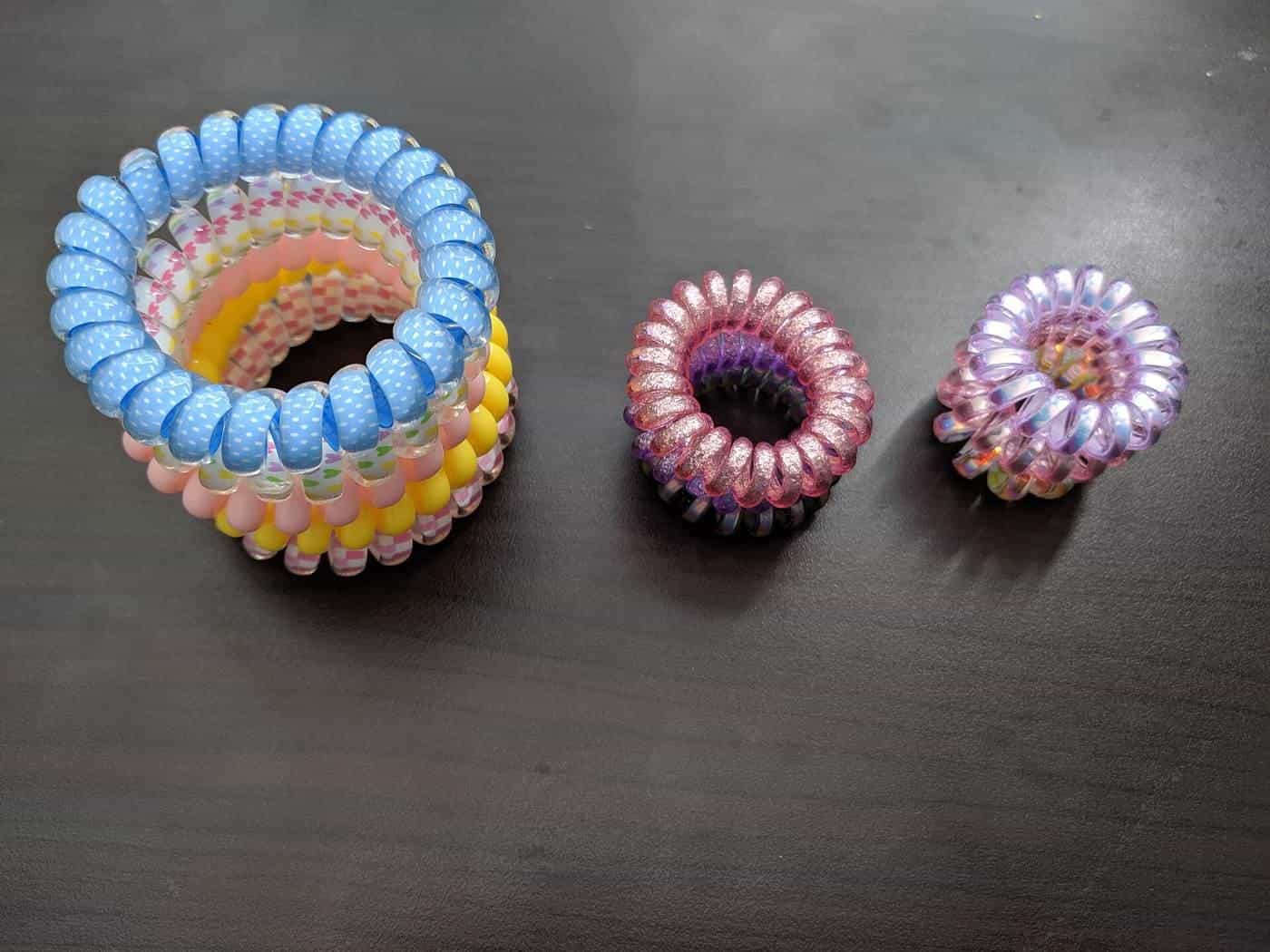 Coiled spiral hair ties in pastel colours lined up on a table