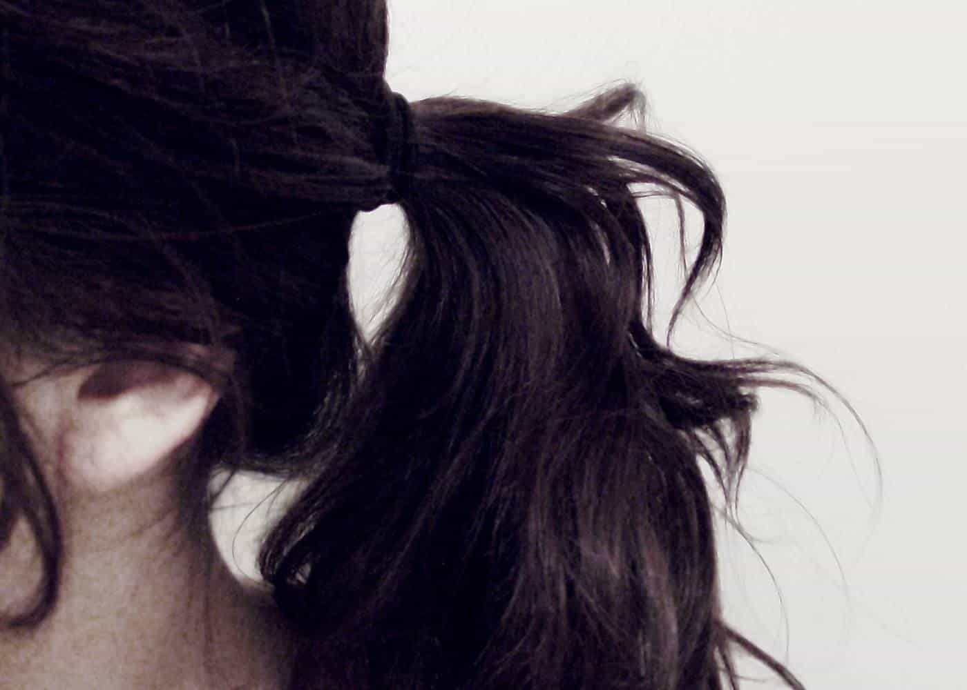 Long dark hair tied in a loose ponytail