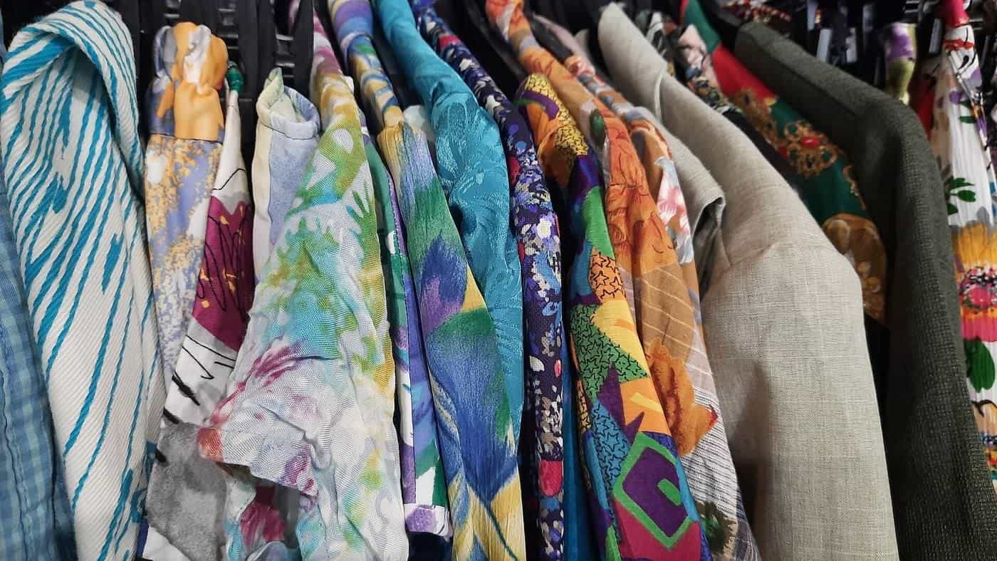 Racks of colourful vintage clothing in a second-hand shop