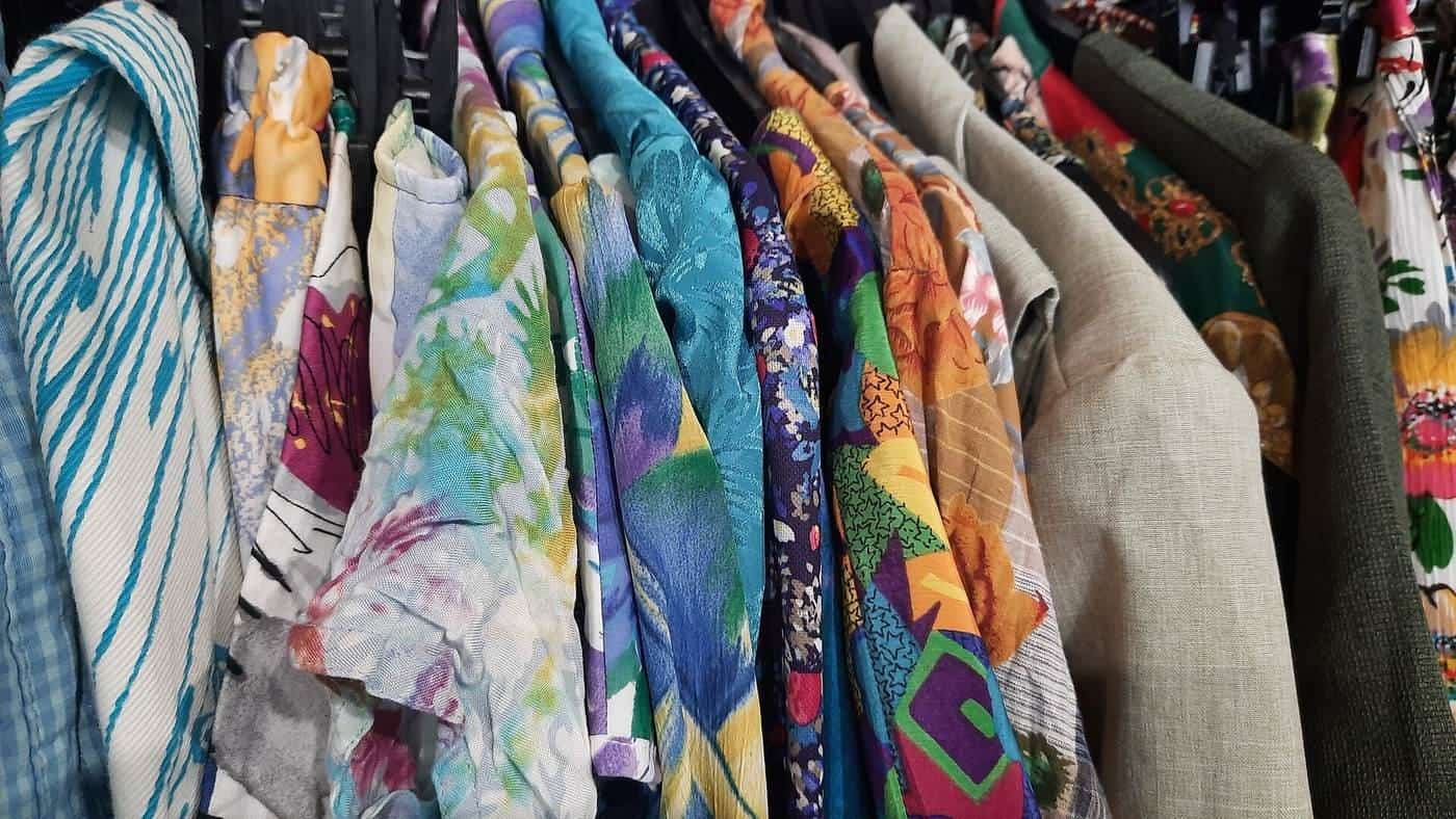 Racks of colourful vintage clothing in a second-hand shop
