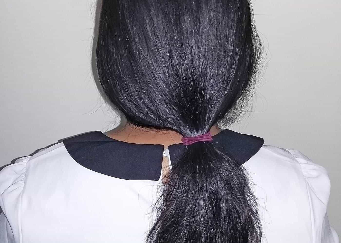 A low ponytail of long black hair seen from behind